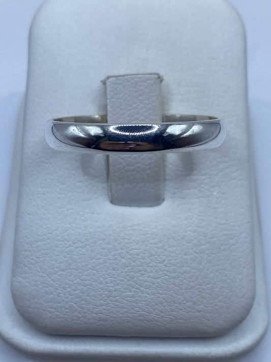Anillo de plata banda pulida minimalista en mano de mujer