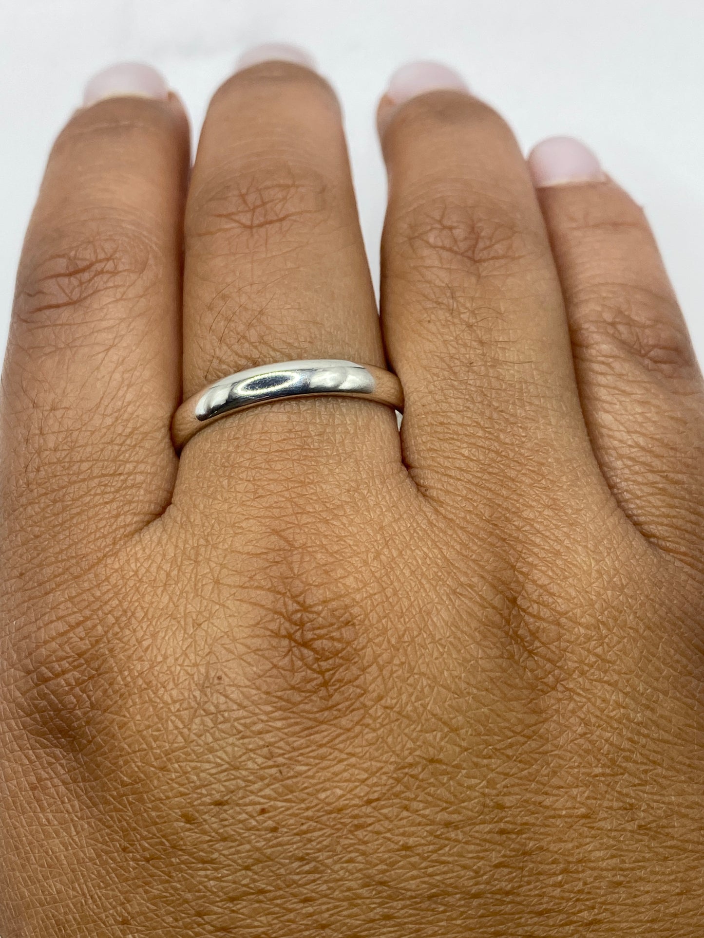 Anillo banda sobre fondo gris mostrando el brillo del pulido