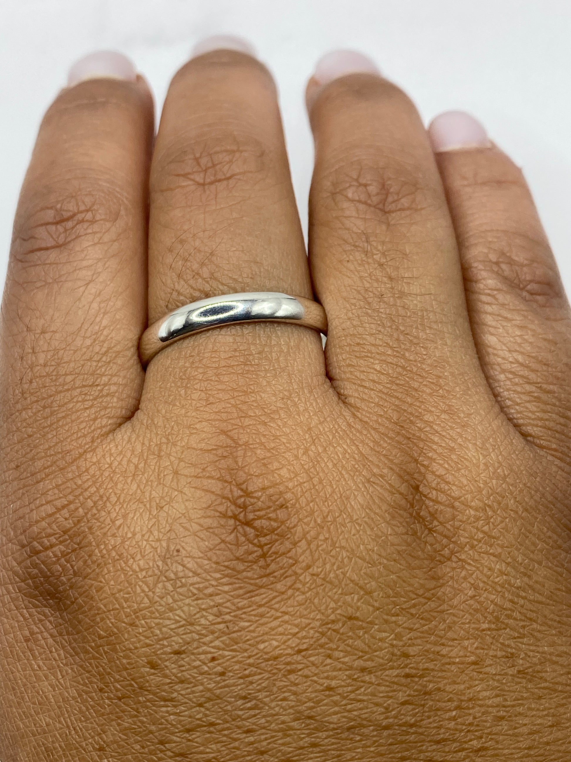 Anillo banda sobre fondo gris mostrando el brillo del pulido