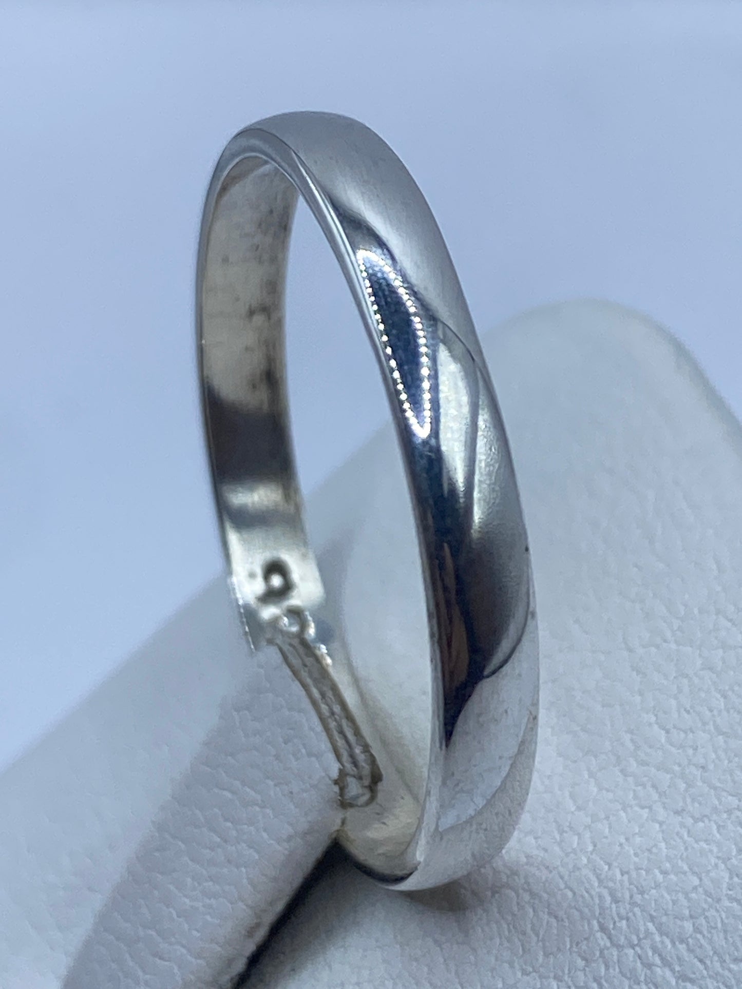 Anillo de plata puesto en dedo masculino con acabado brillo espejo