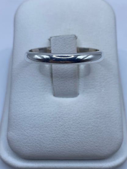 Anillo de plata banda pulida en dedo de mujer mostrando el brillo minimalista