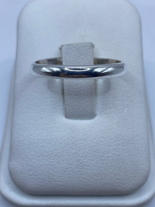 Anillo de plata banda pulida en dedo de mujer mostrando el brillo minimalista