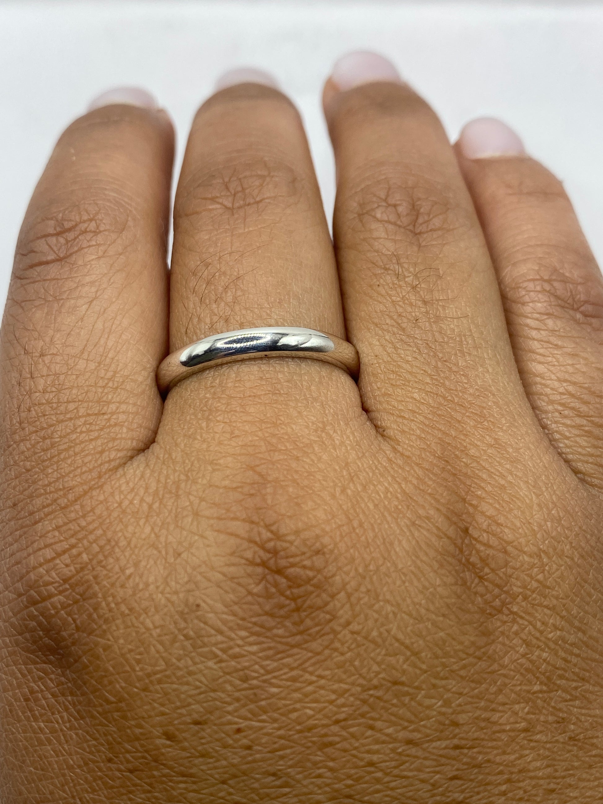 Anillo banda de plata con sello .925 en fondo blanco