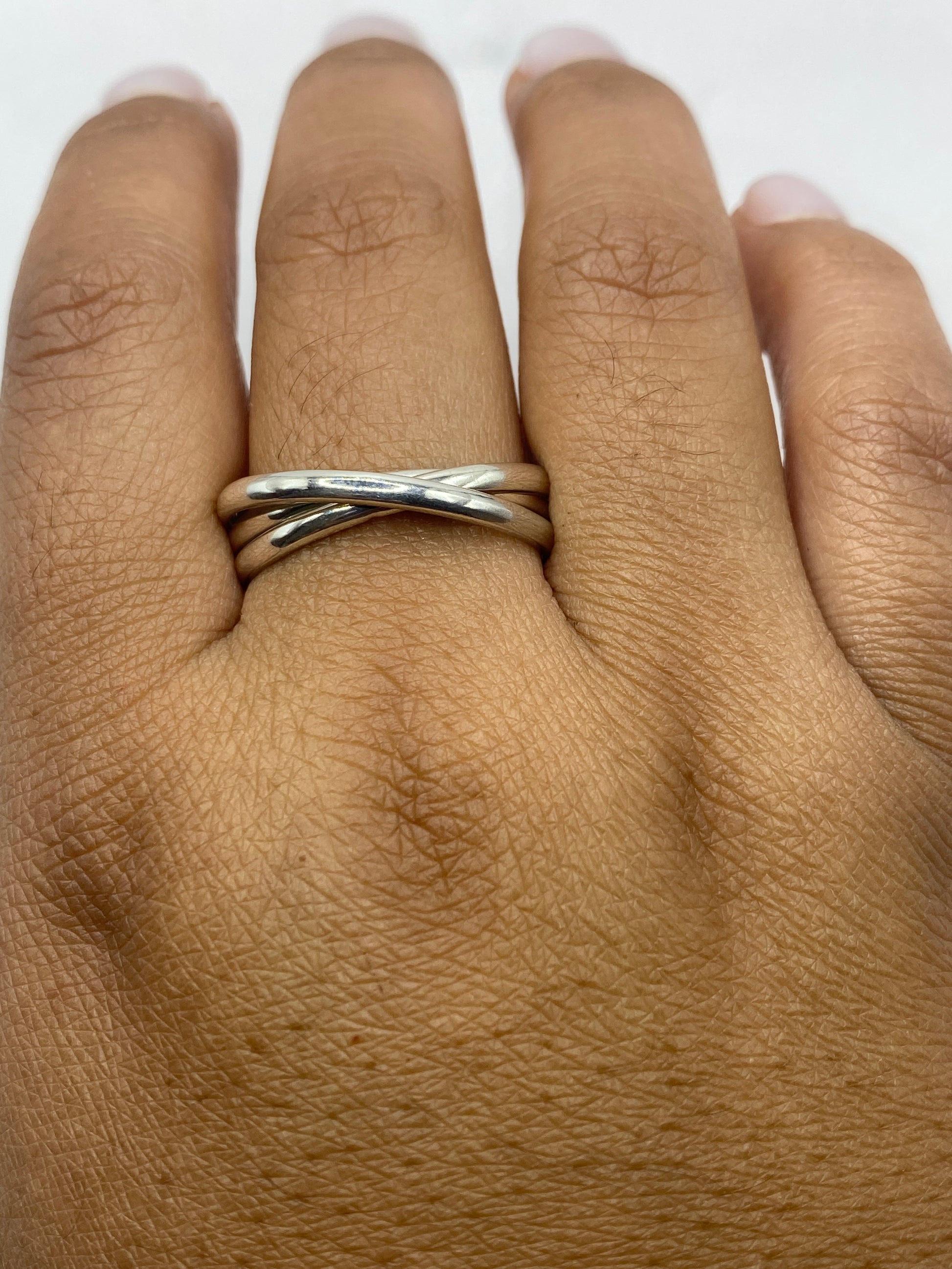 Anillo de bandas en la mano de una mujer mostrando el acabado espejo