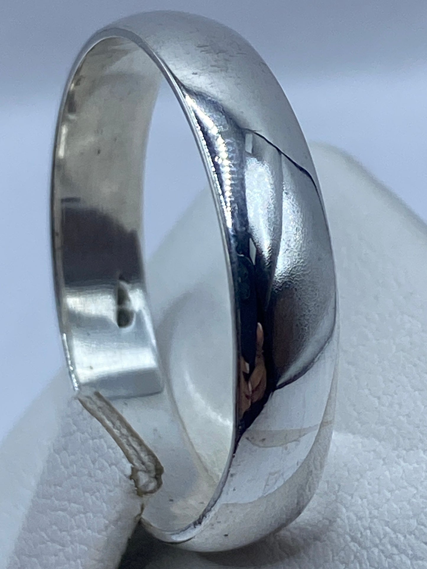 Anillo pulido en la mano mostrando el reflejo de luz en su superficie