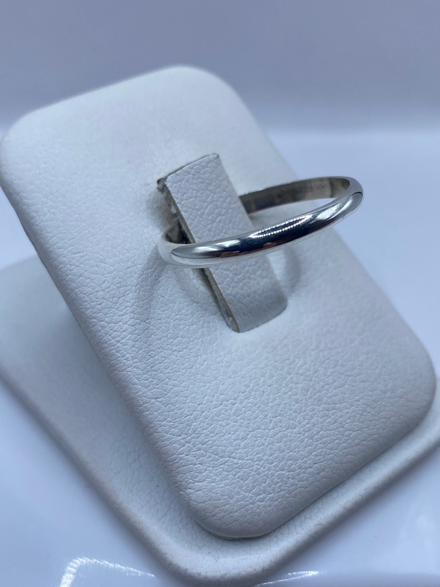 Anillo clásico de plata en perfil lateral, mostrando el pulido brillante