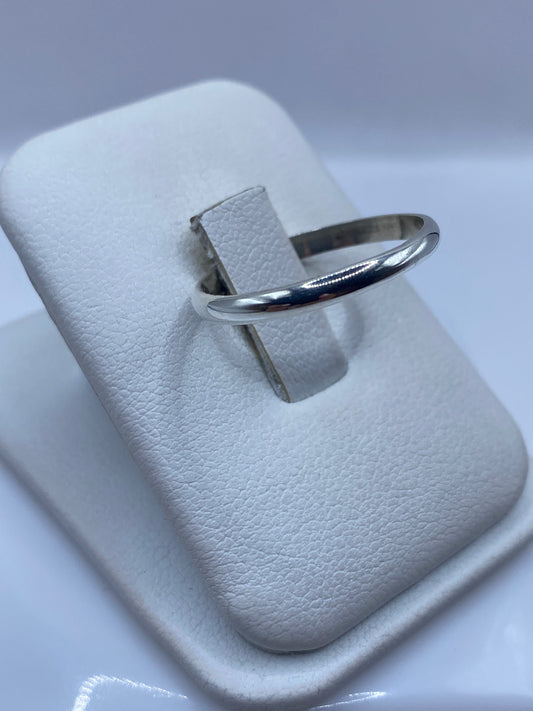 Anillo clásico de plata en perfil lateral, mostrando el pulido brillante
