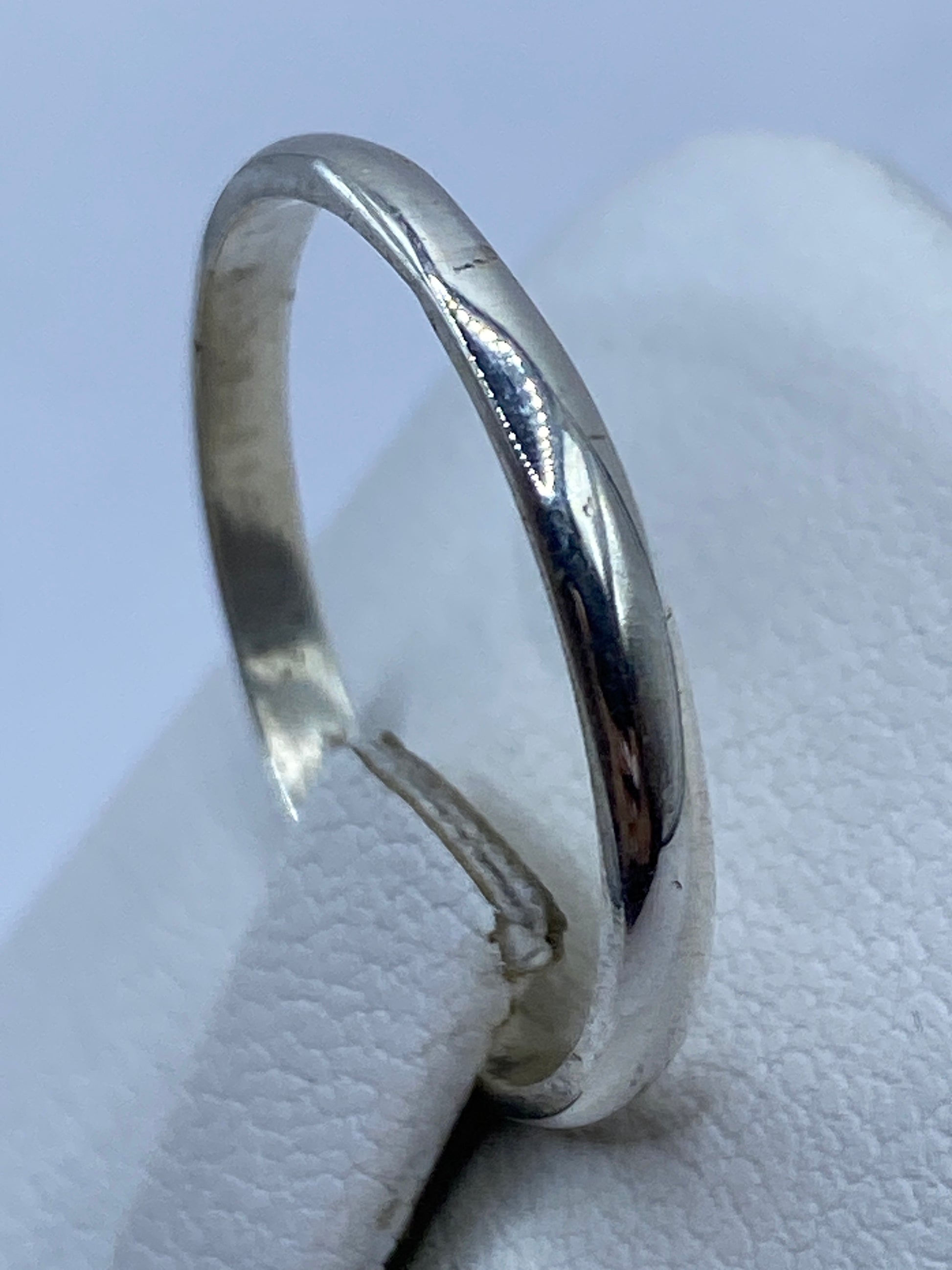 Detalle de banda lisa de plata pura llevada en dedo, uso diario