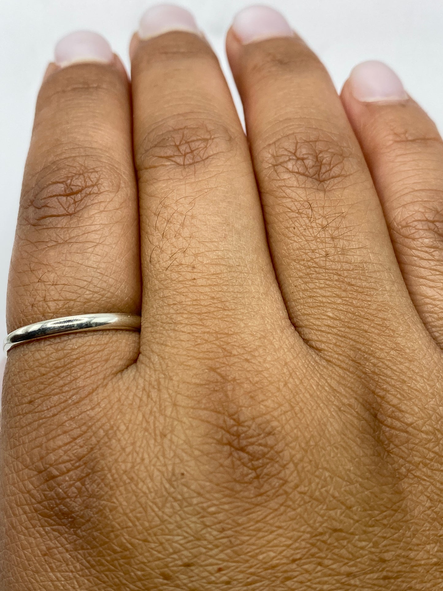 Anillo sobre superficie gris mostrando sello .925 y peso de 1.5 gramos