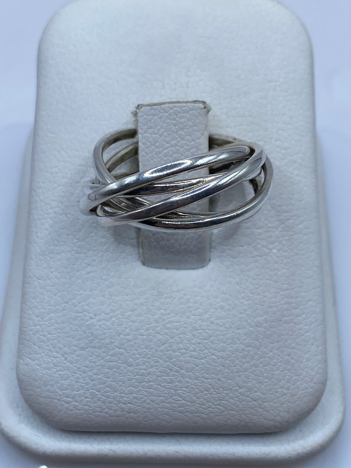 Anillo de plata entrelazado en la mano mostrando el diseño dinámico