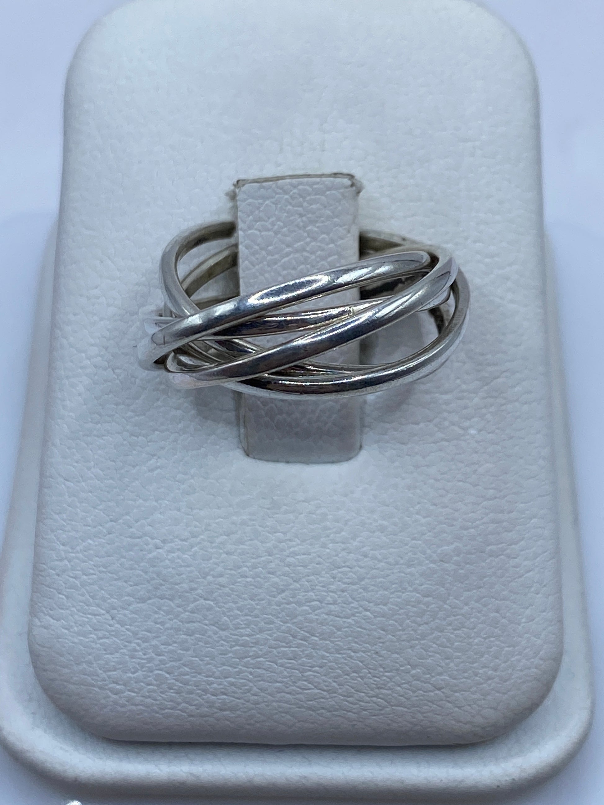 Anillo de plata entrelazado en la mano mostrando el diseño dinámico