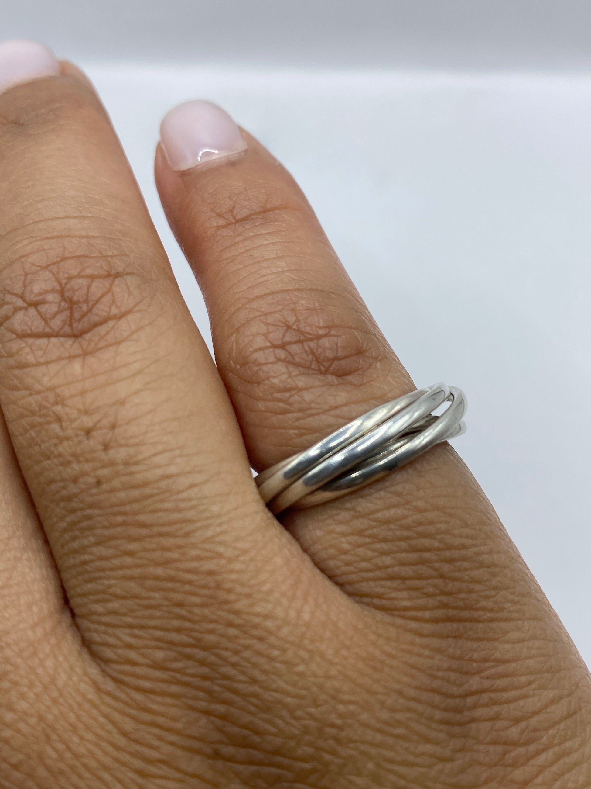 Anillo en la mano sobre fondo blanco mostrando brillo de pulido espejo
