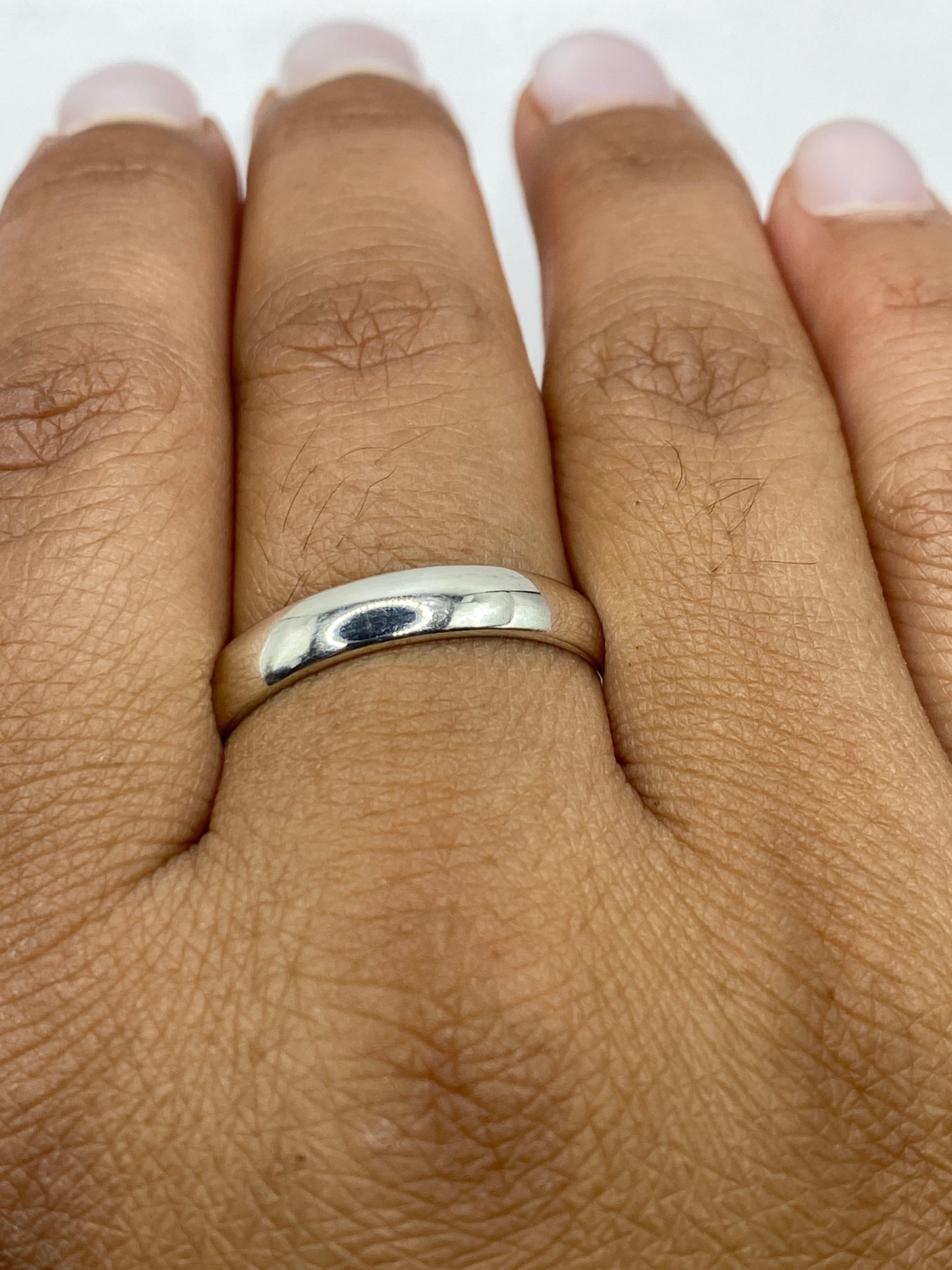 Anillo banda sobre fondo blanco destacando su línea pura y elegante