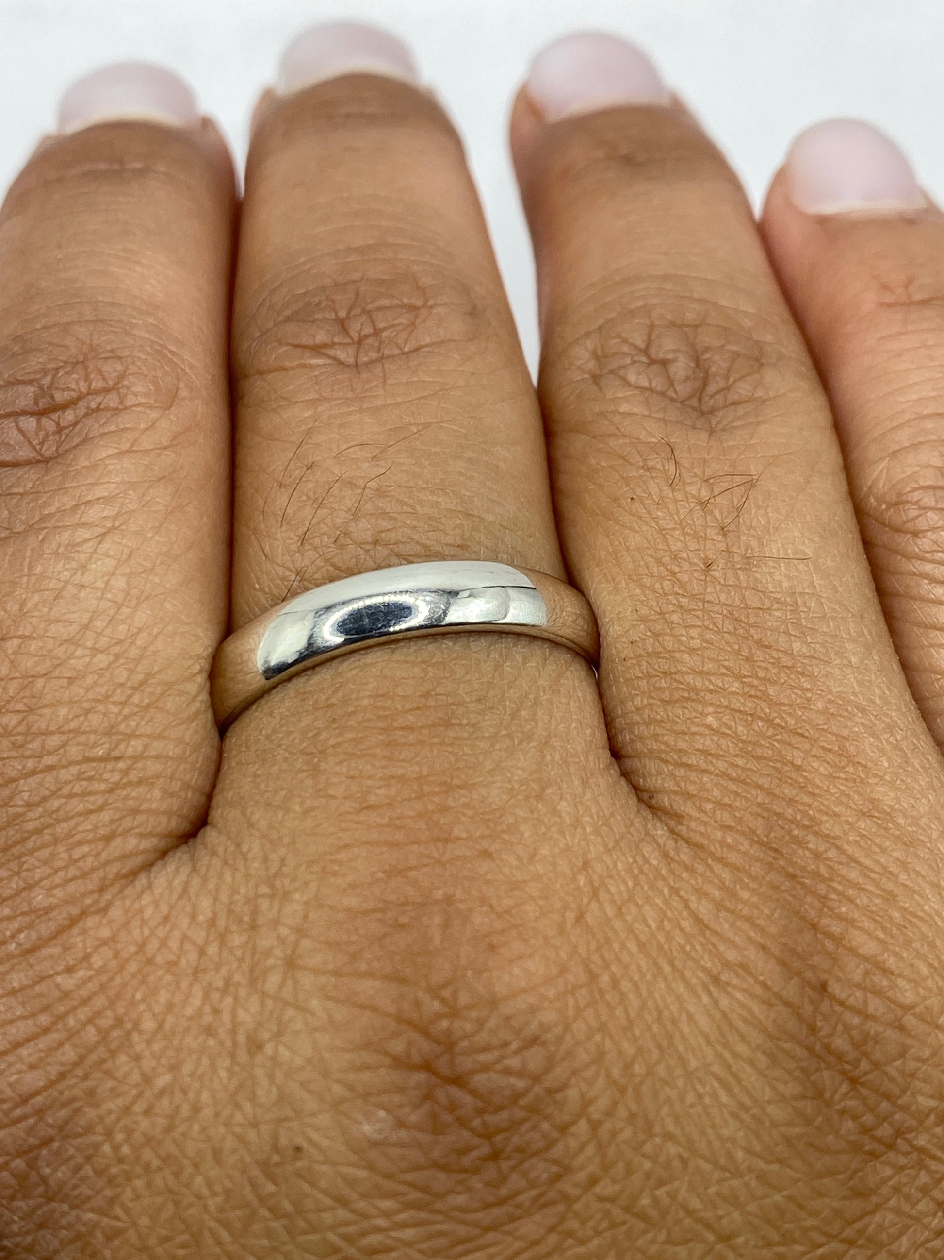 Anillo banda sobre fondo blanco destacando su línea pura y elegante
