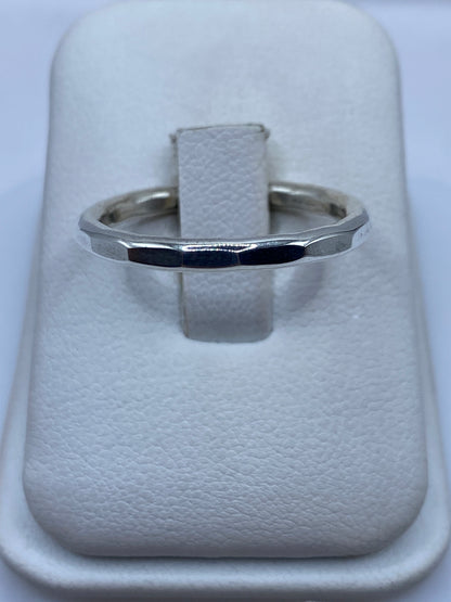 Anillo de plata banda pulida minimalista en dedo de mujer