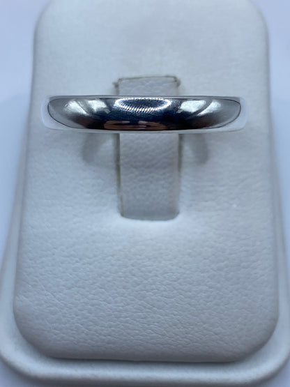 Anillo de plata lisa pulida en caja blanca, vista frontal