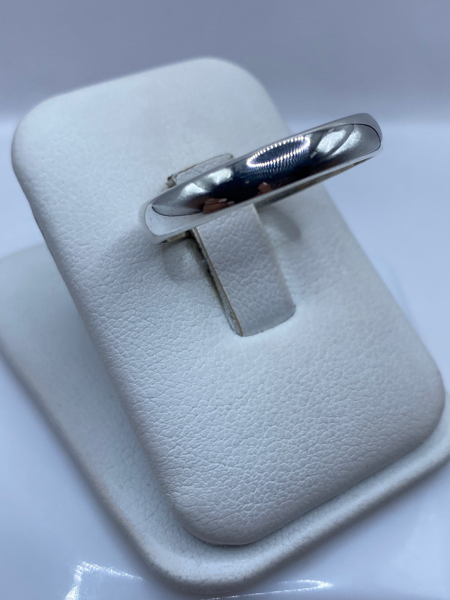 Anillo de plata banda redondeada en dedo masculino, detalle lateral