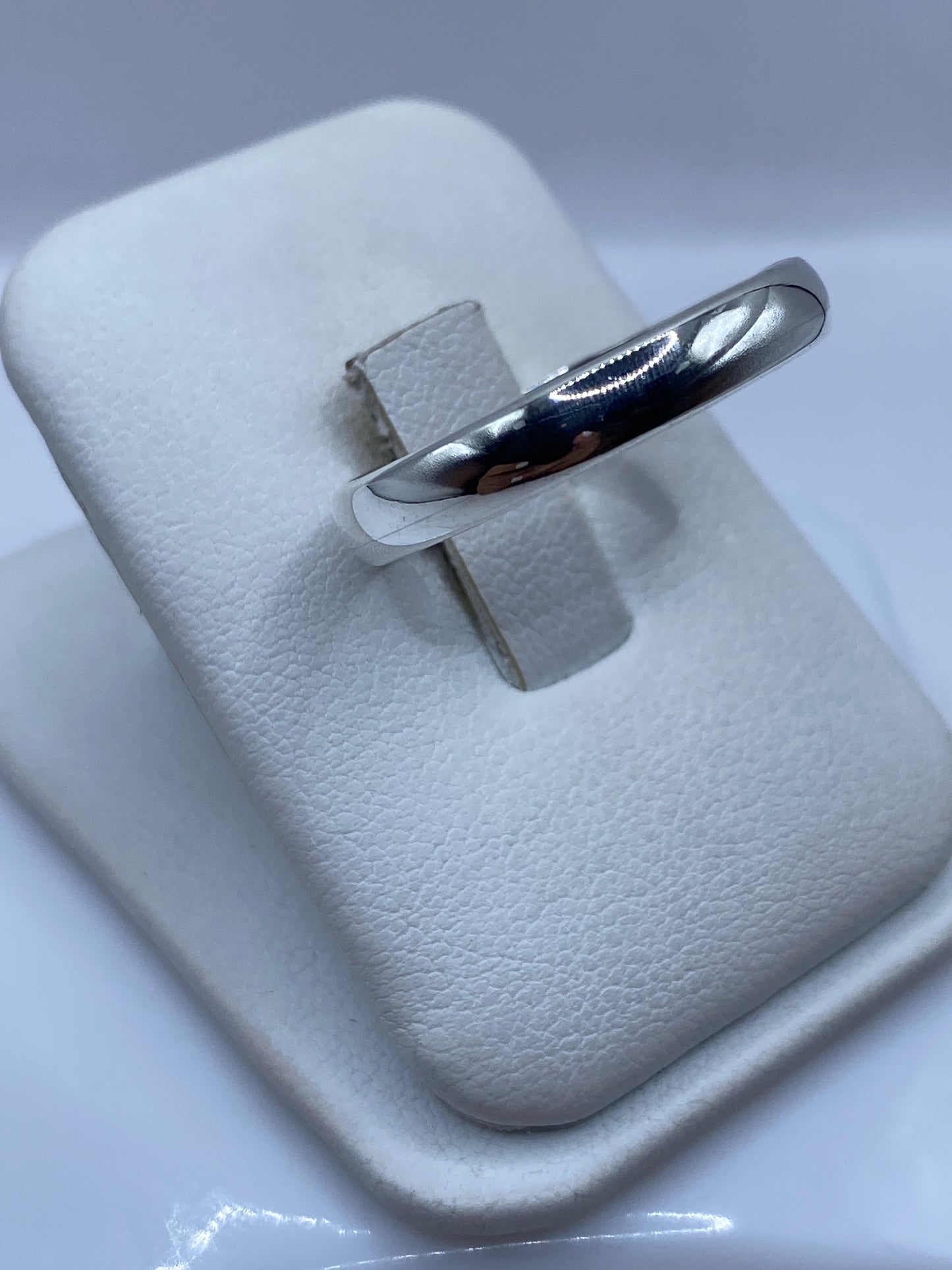 Anillo banda minimalista en dedo, mostrando pulido espejo y proporciones perfectas
