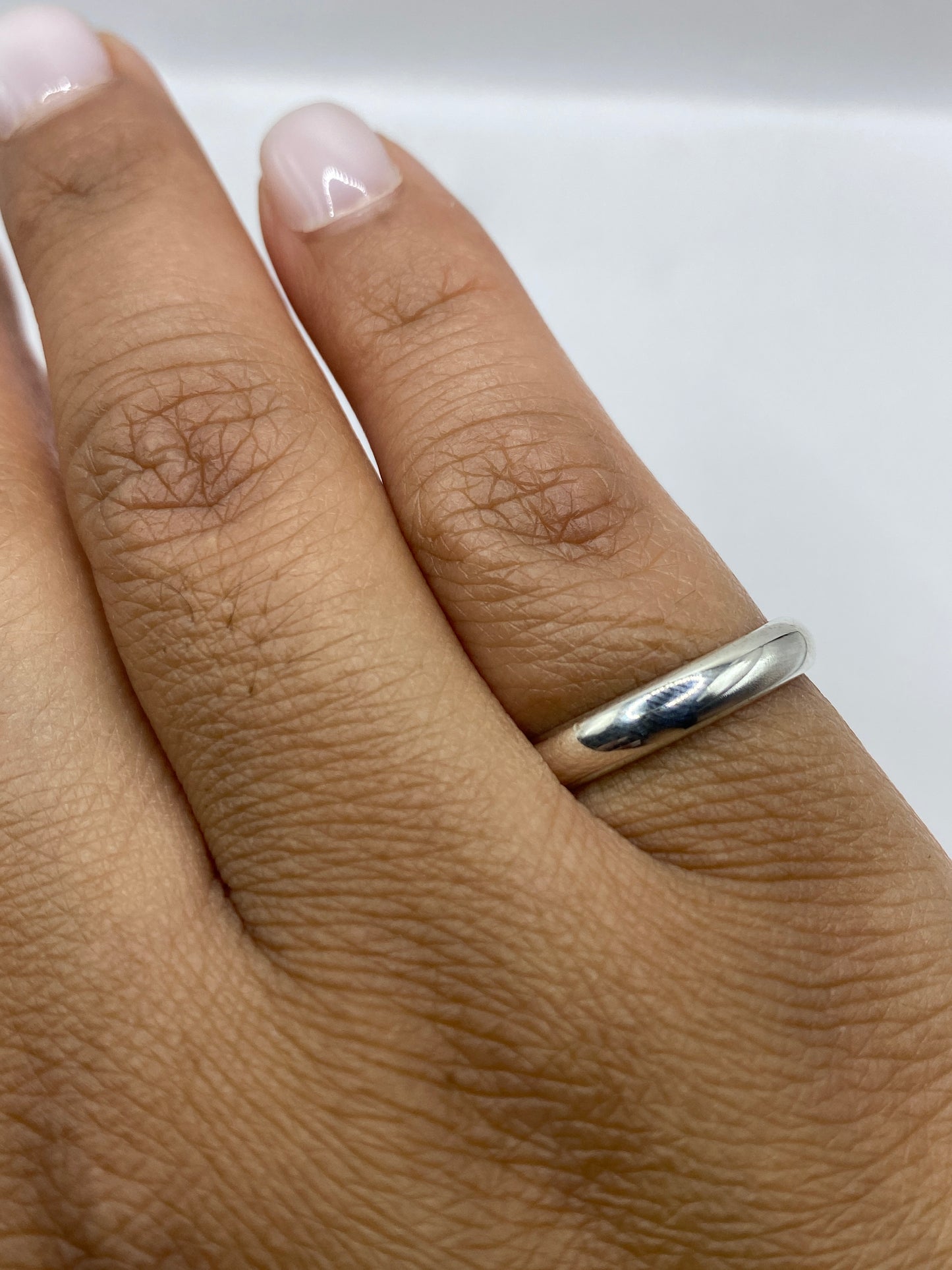 Anillo de plata sobre fondo blanco mostrando el sello 925 en la banda