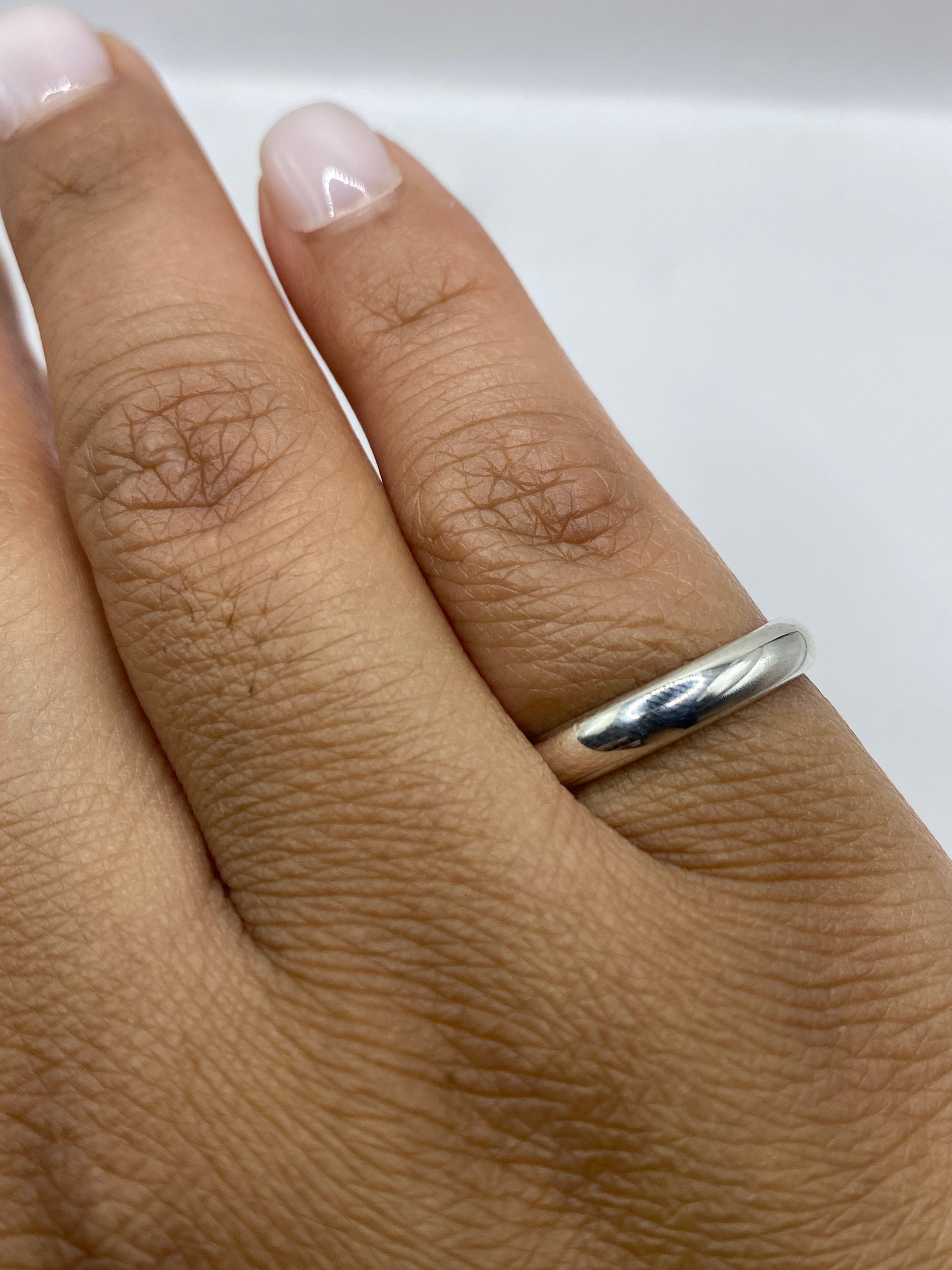 Anillo de plata sobre fondo blanco mostrando el sello 925 en la banda