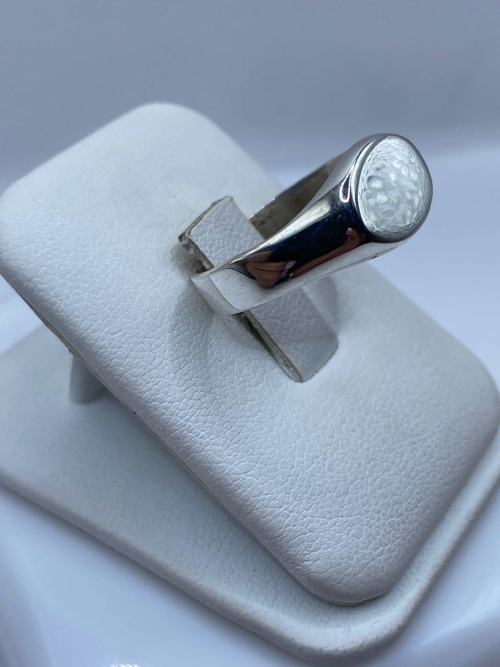 Anillo minimalista en plata .925 en la mano, mostrando el pulido espejo