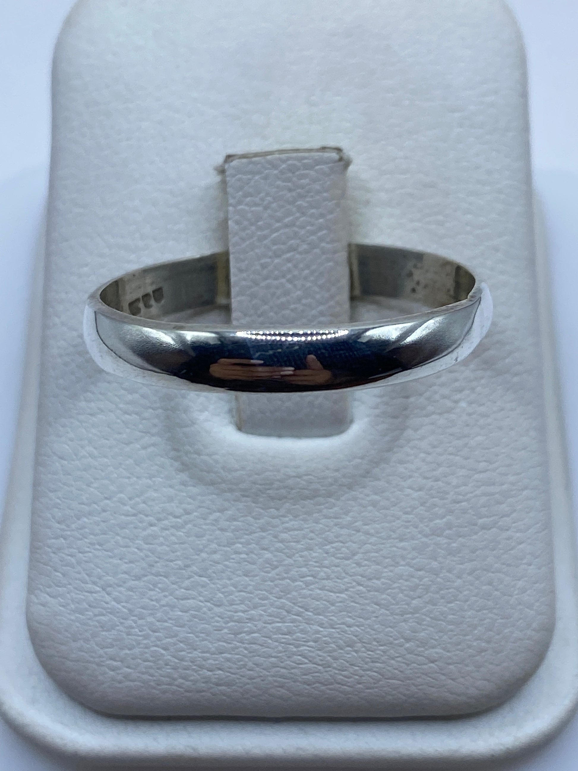Anillo de plata banda minimalista pulida en el dedo de una mujer