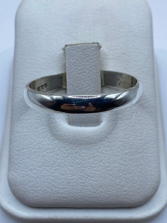 Anillo de plata banda minimalista pulida en el dedo de una mujer
