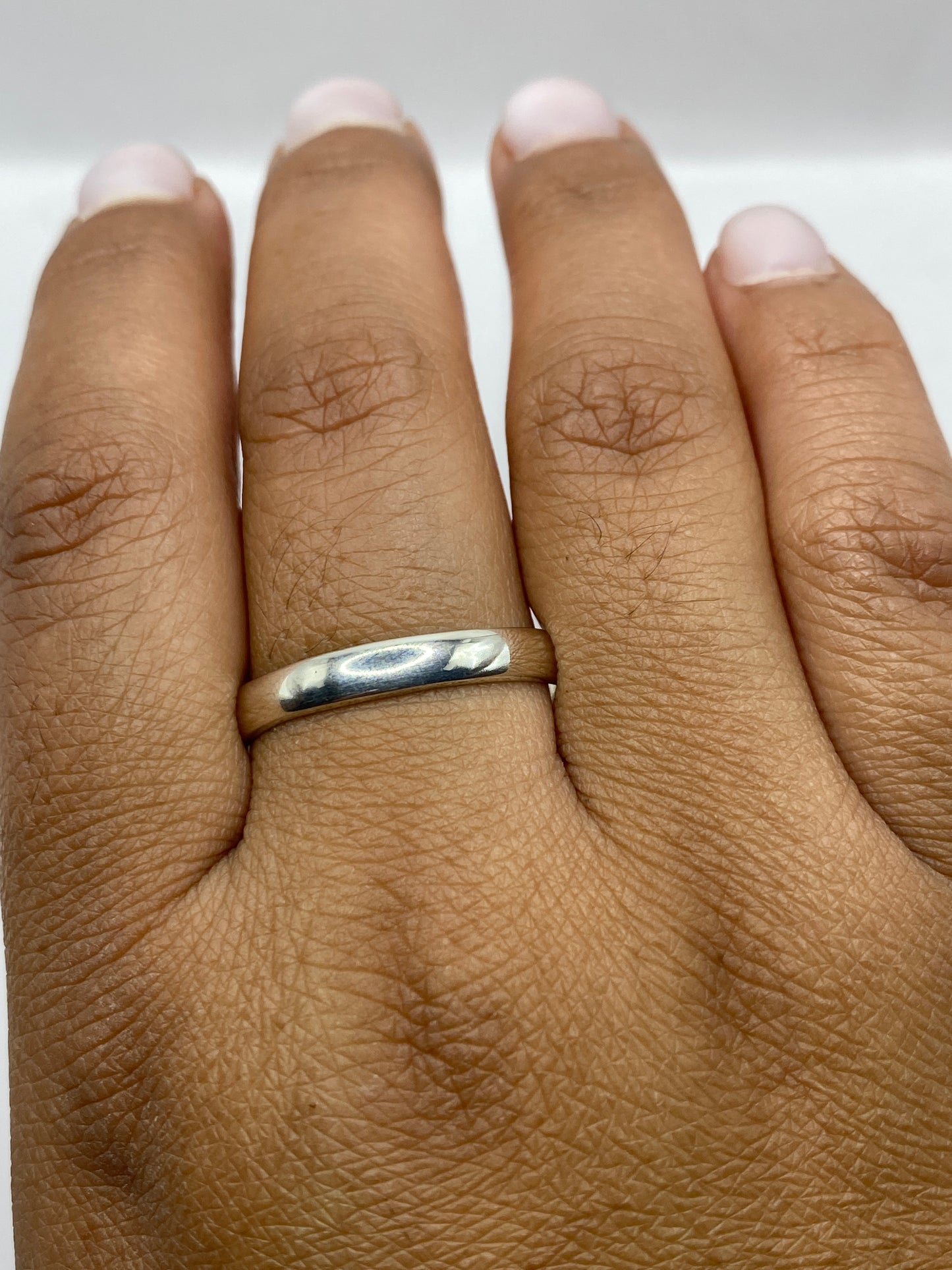 Anillo minimalista sobre fondo blanco, mostrando el brillo del pulido