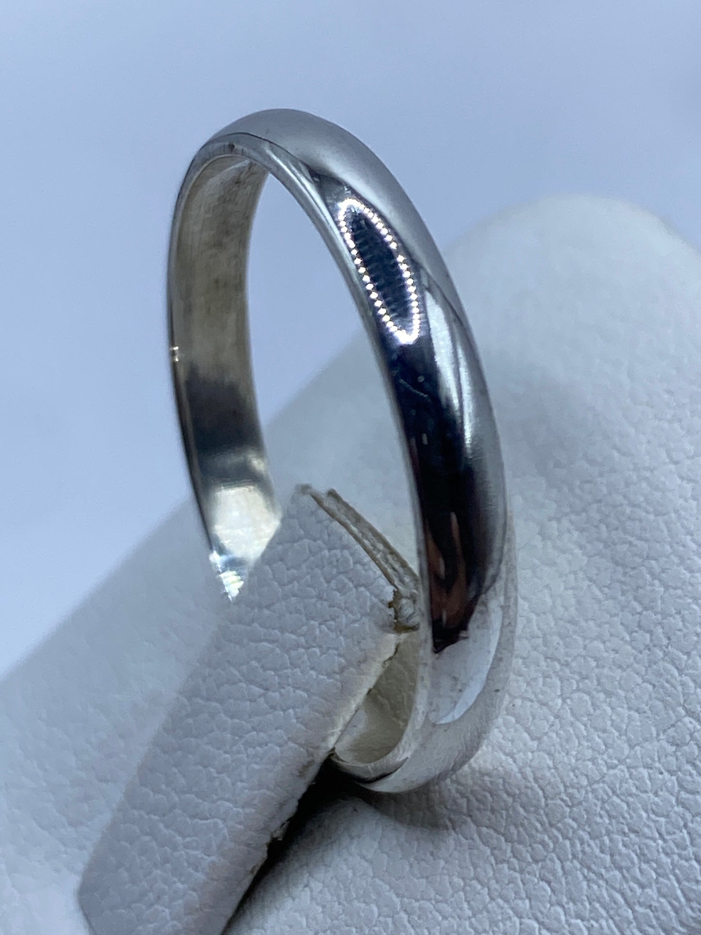 Anillo banda de plata .925 en la mano, mostrando el acabado y el sello 925
