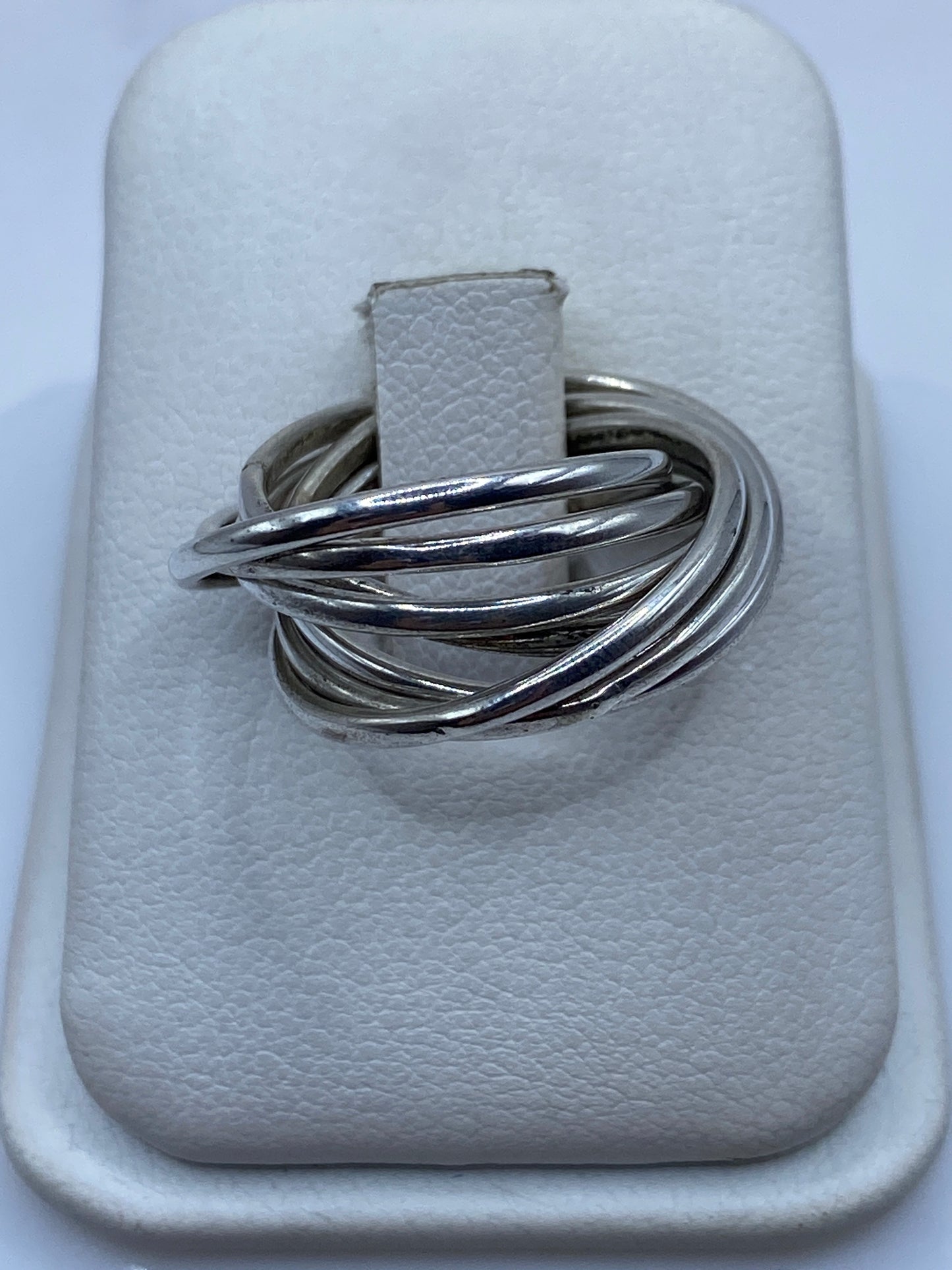 Anillo de plata con bandas entrelazadas visto desde arriba en estuche blanco