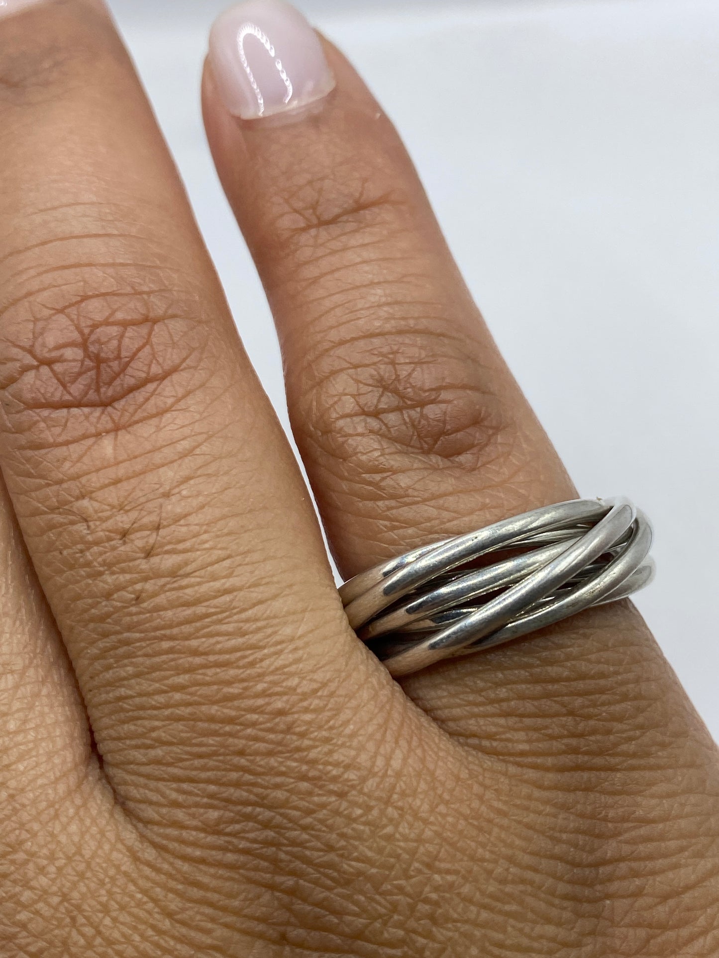 Anillo de plata sobre fondo gris mostrando el peso y brillo del material