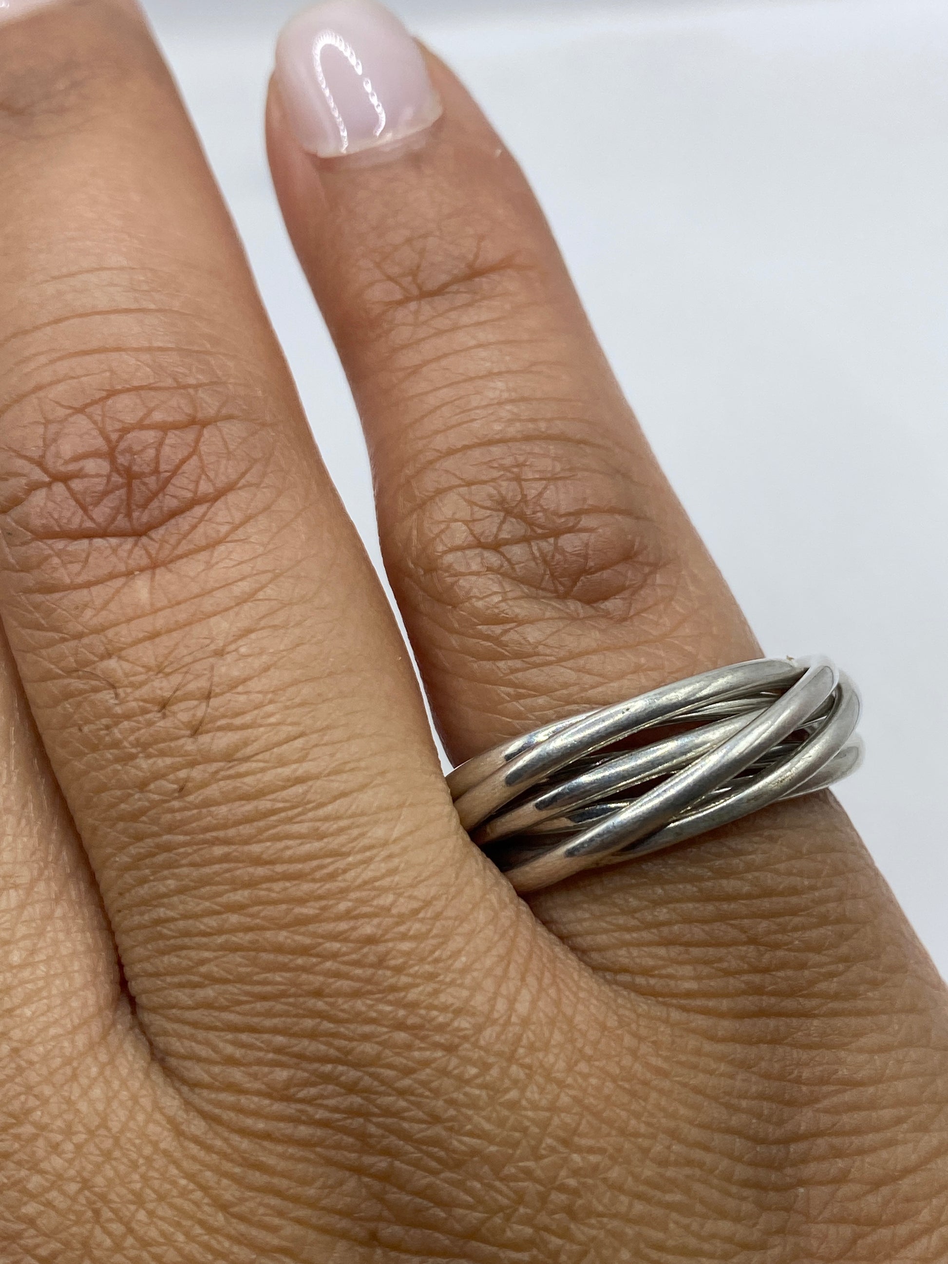 Anillo de plata sobre fondo gris mostrando el peso y brillo del material