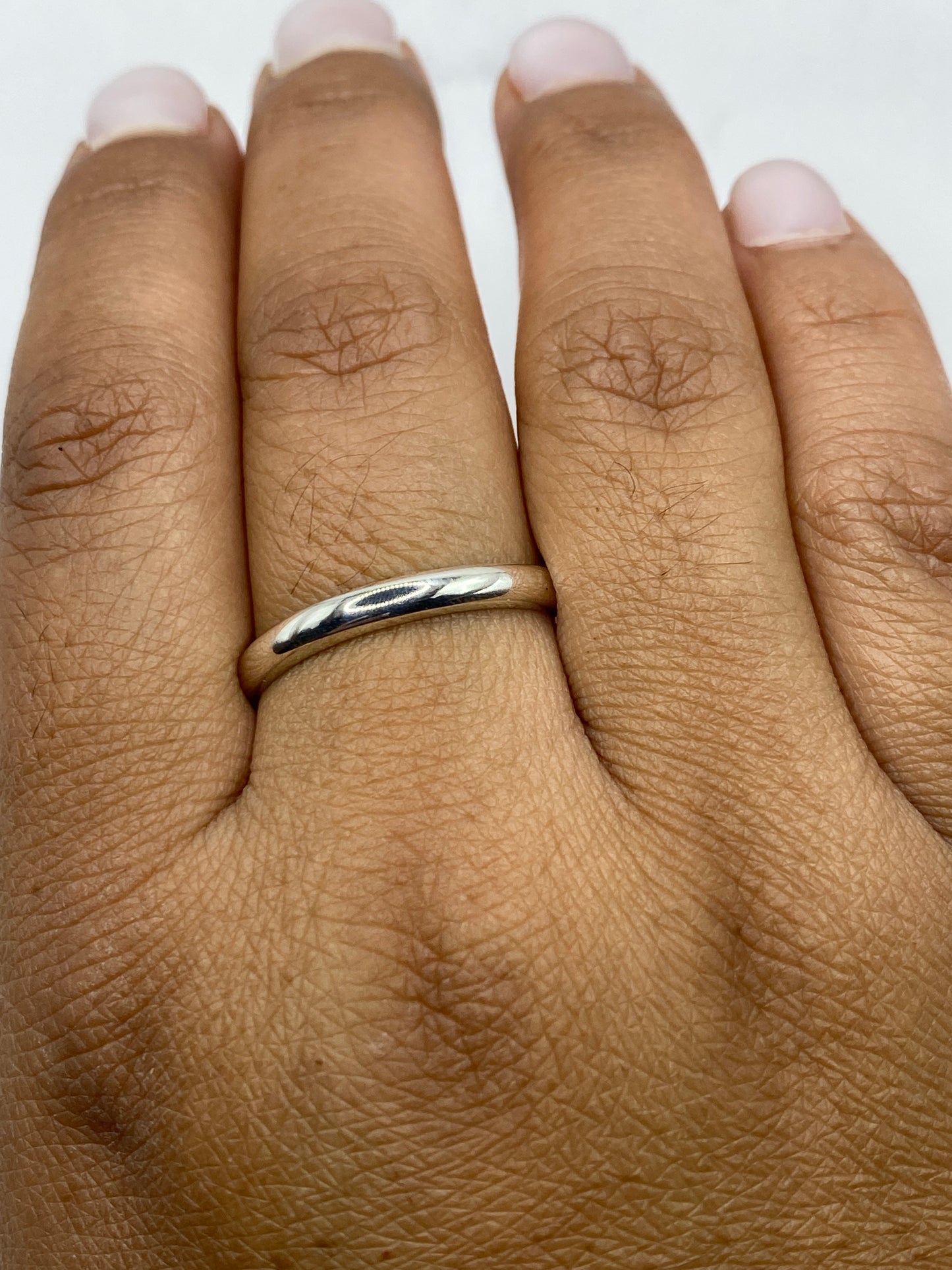 Anillo banda sobre escala con sello .925 visible en el interior