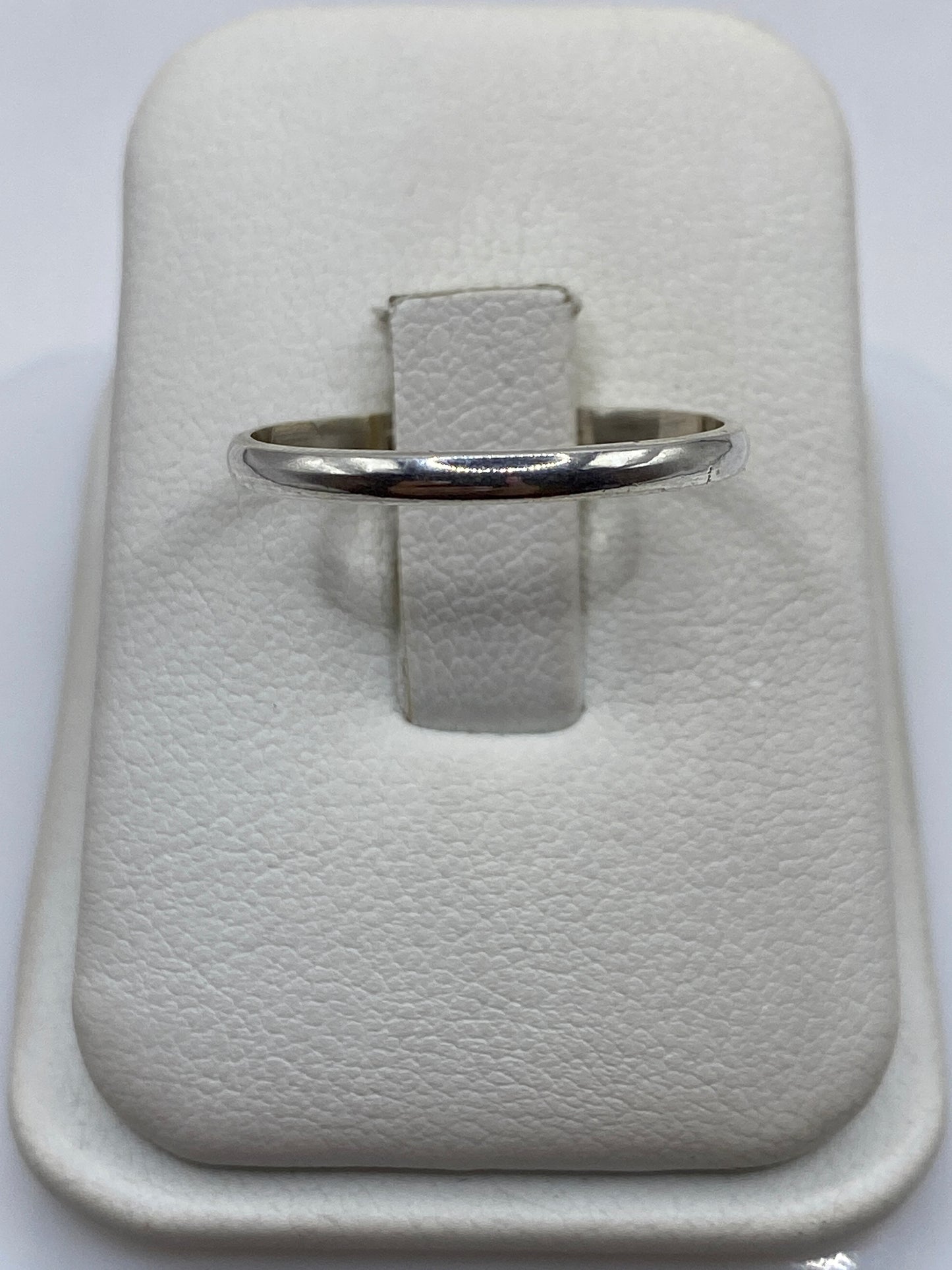 Anillo de plata banda pulida minimalista en dedo de mujer