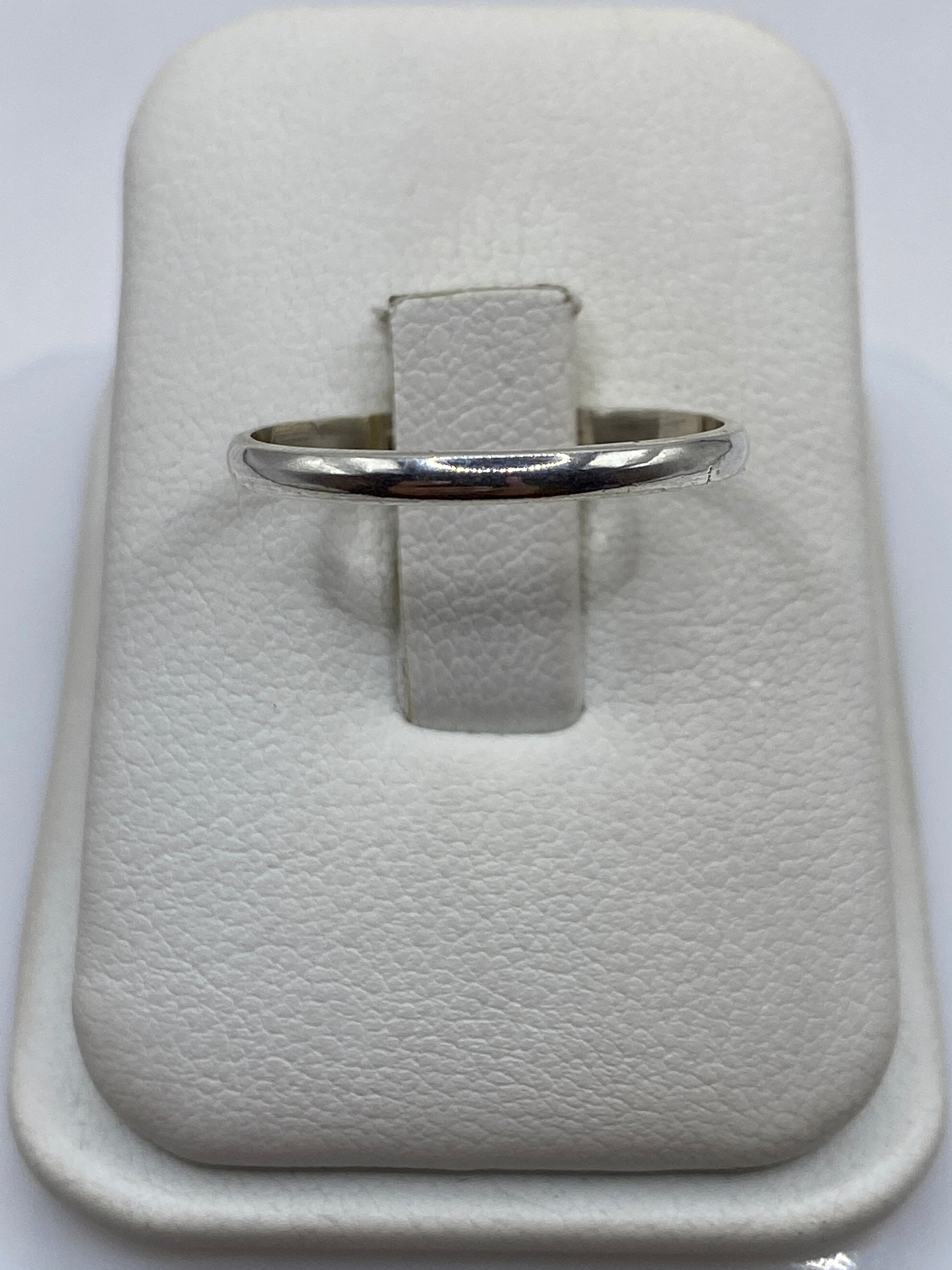 Anillo de plata banda pulida minimalista en dedo de mujer