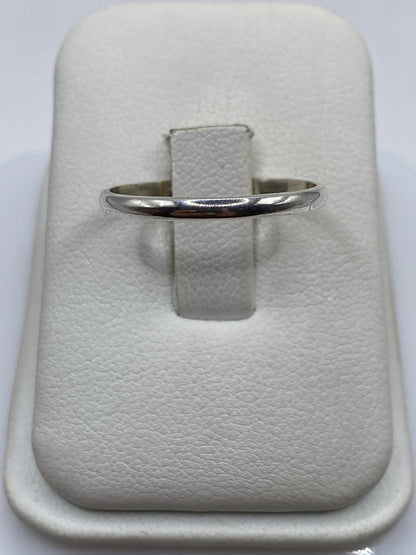 Anillo de plata banda pulida minimalista en dedo de mujer
