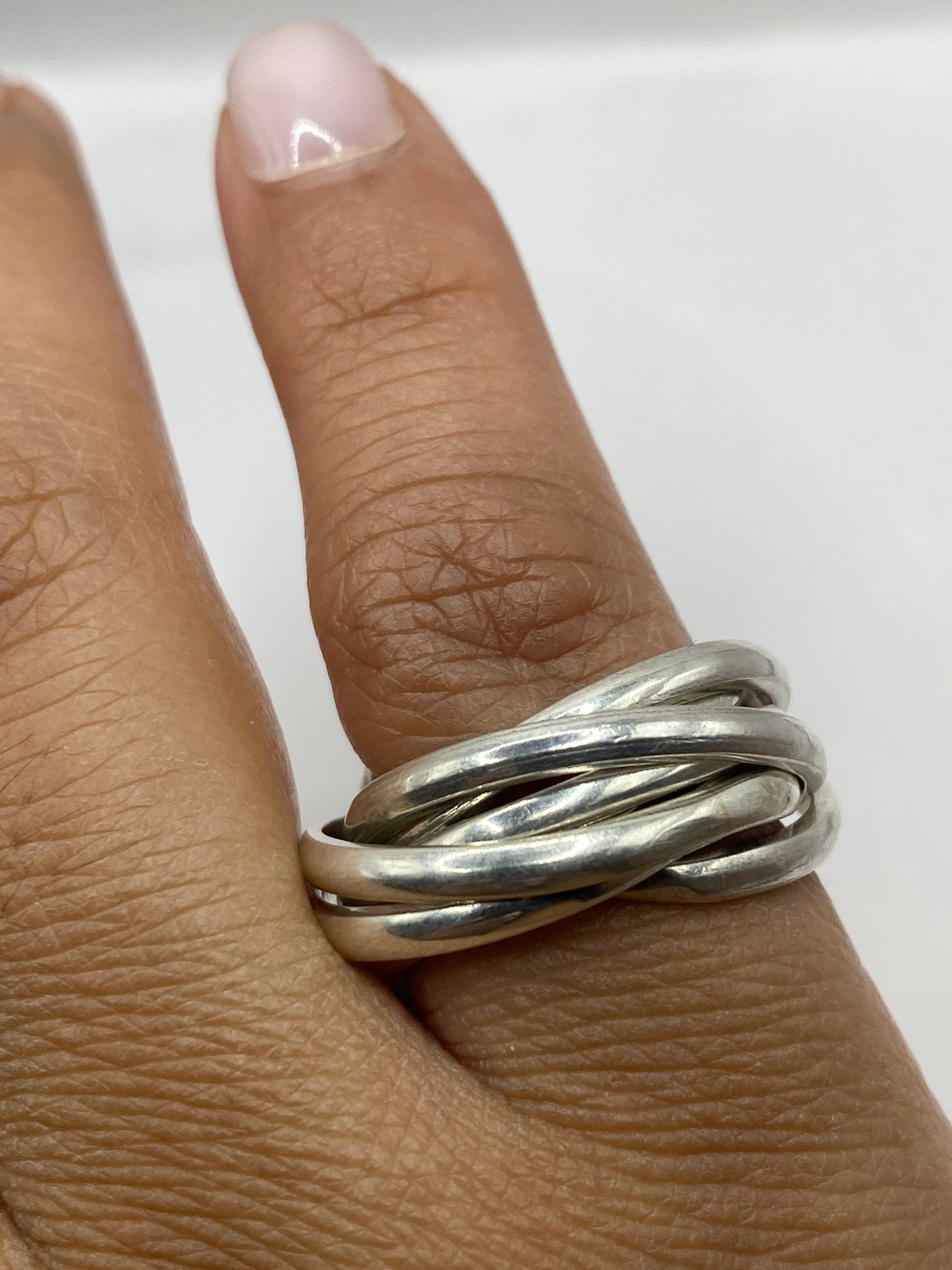 Anillo entrelazado de Taxco sobre superficie neutra mostrando el peso y volumen de la pieza