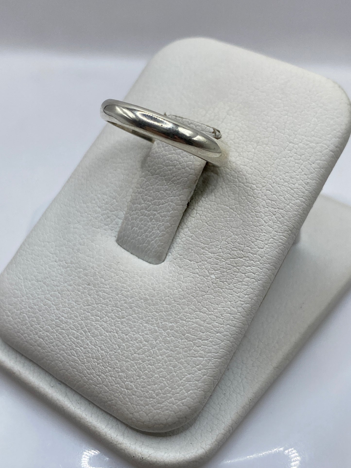 Vista frontal del anillo minimalista de plata pura con diseño banda simple
