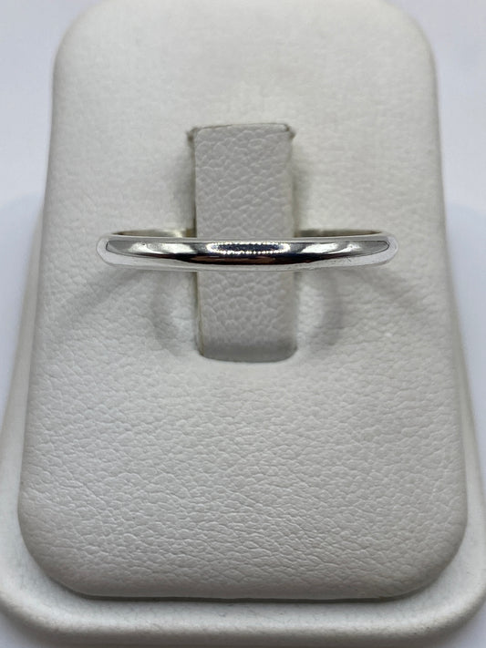 Anillo de plata banda lisa pulida en dedo unisex mostrando el brillo espejo