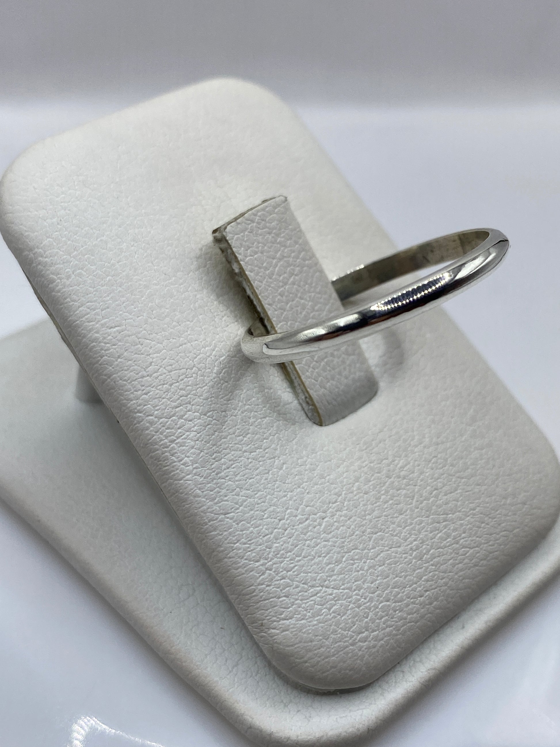 Vista lateral del anillo minimalista de plata .925 en el empaque original