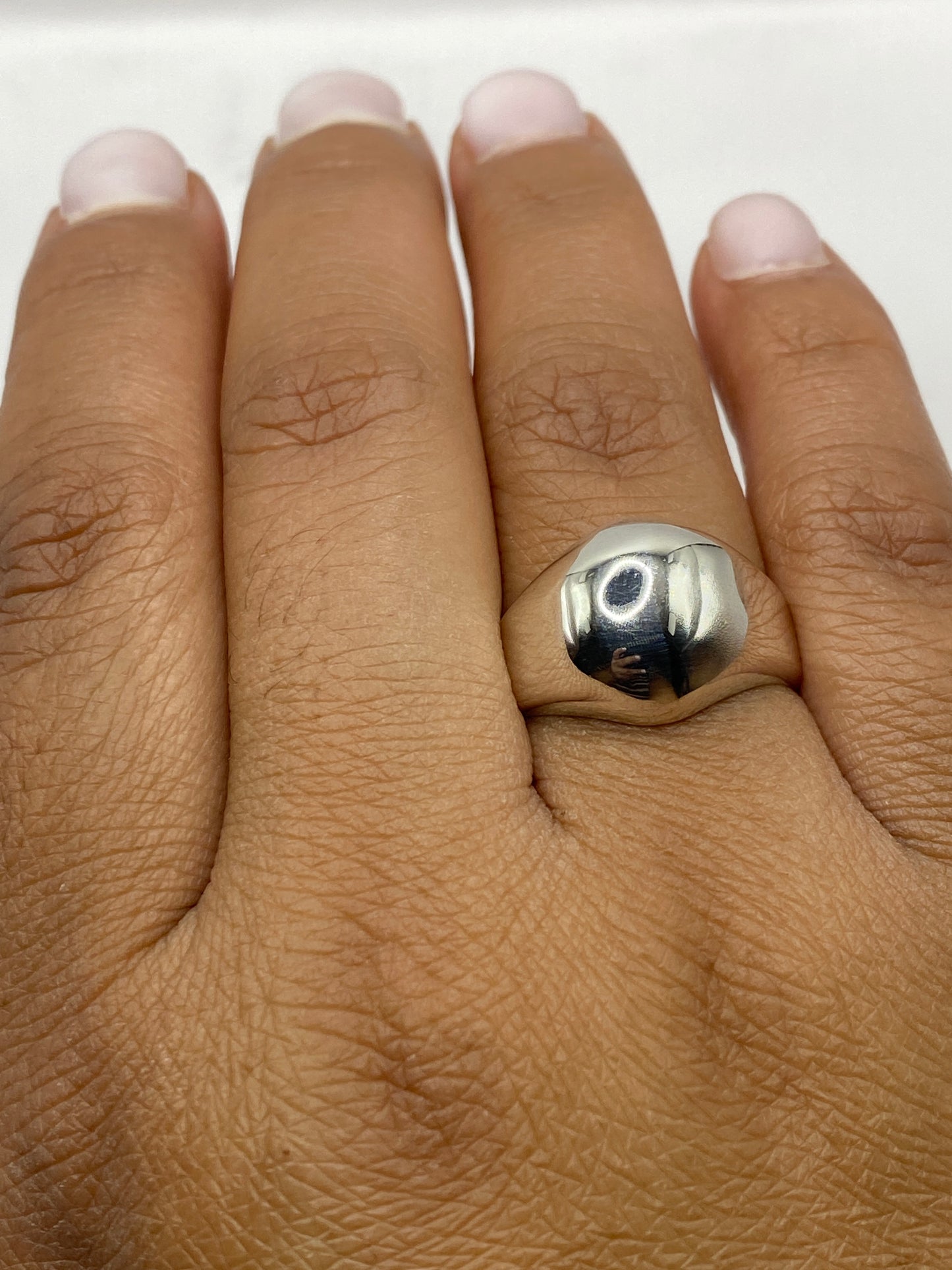 Anillo escultural con sello 925 visible en el interior, fondo gris