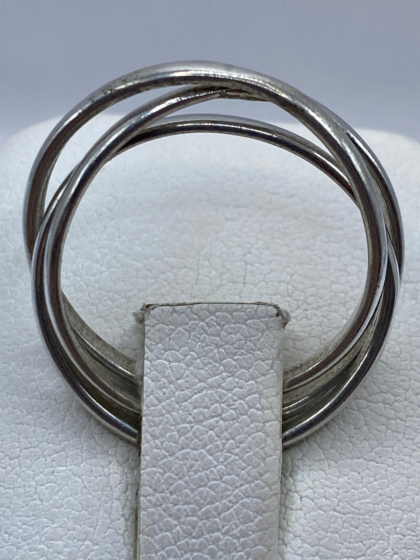 Anillo de tres bandas en la mano de una mujer sobre fondo natural