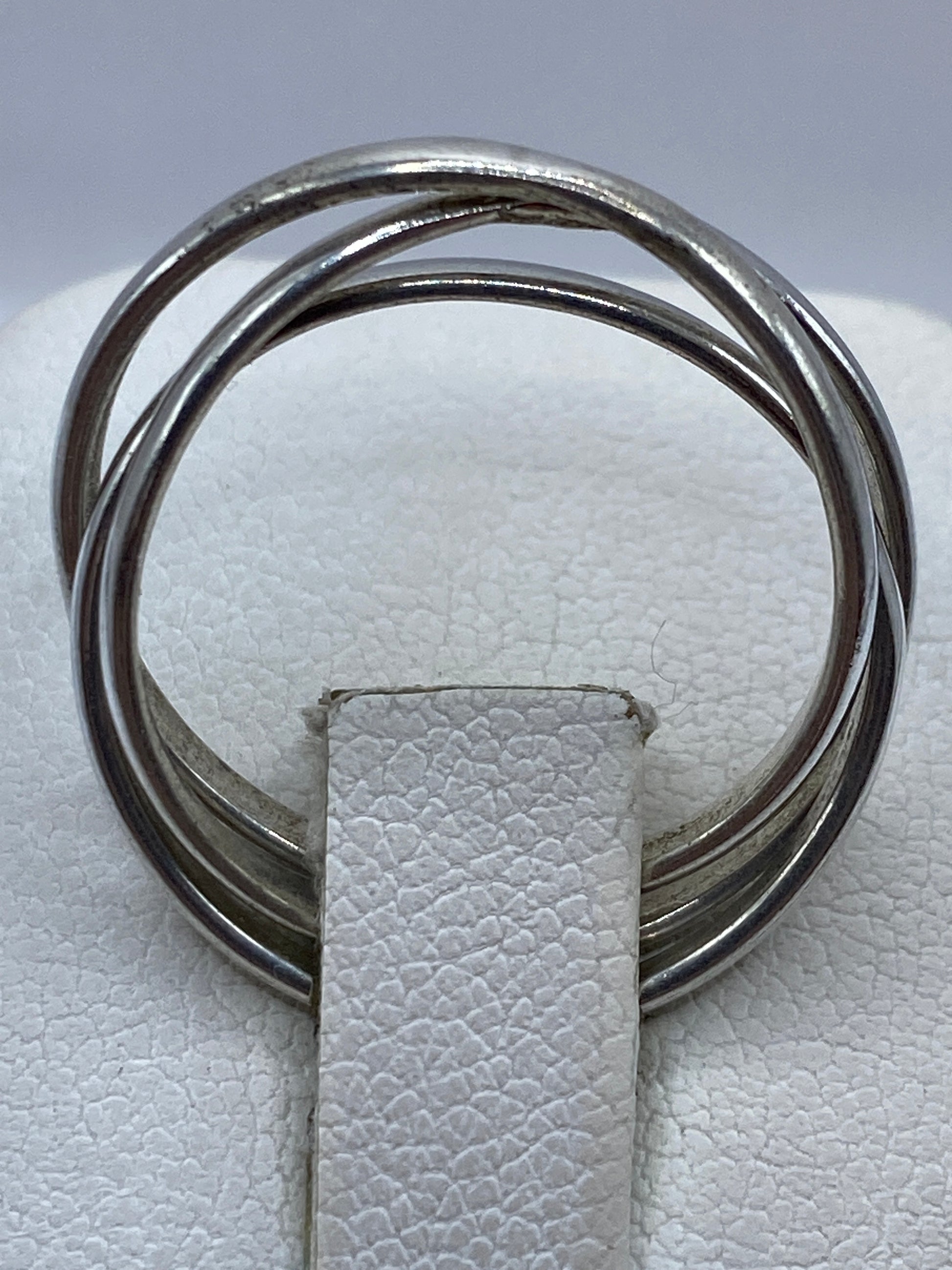 Anillo de tres bandas en la mano de una mujer sobre fondo natural
