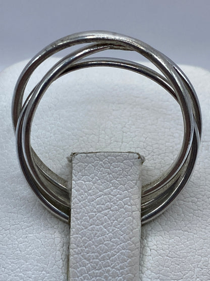 Anillo de tres bandas en la mano de una mujer sobre fondo natural
