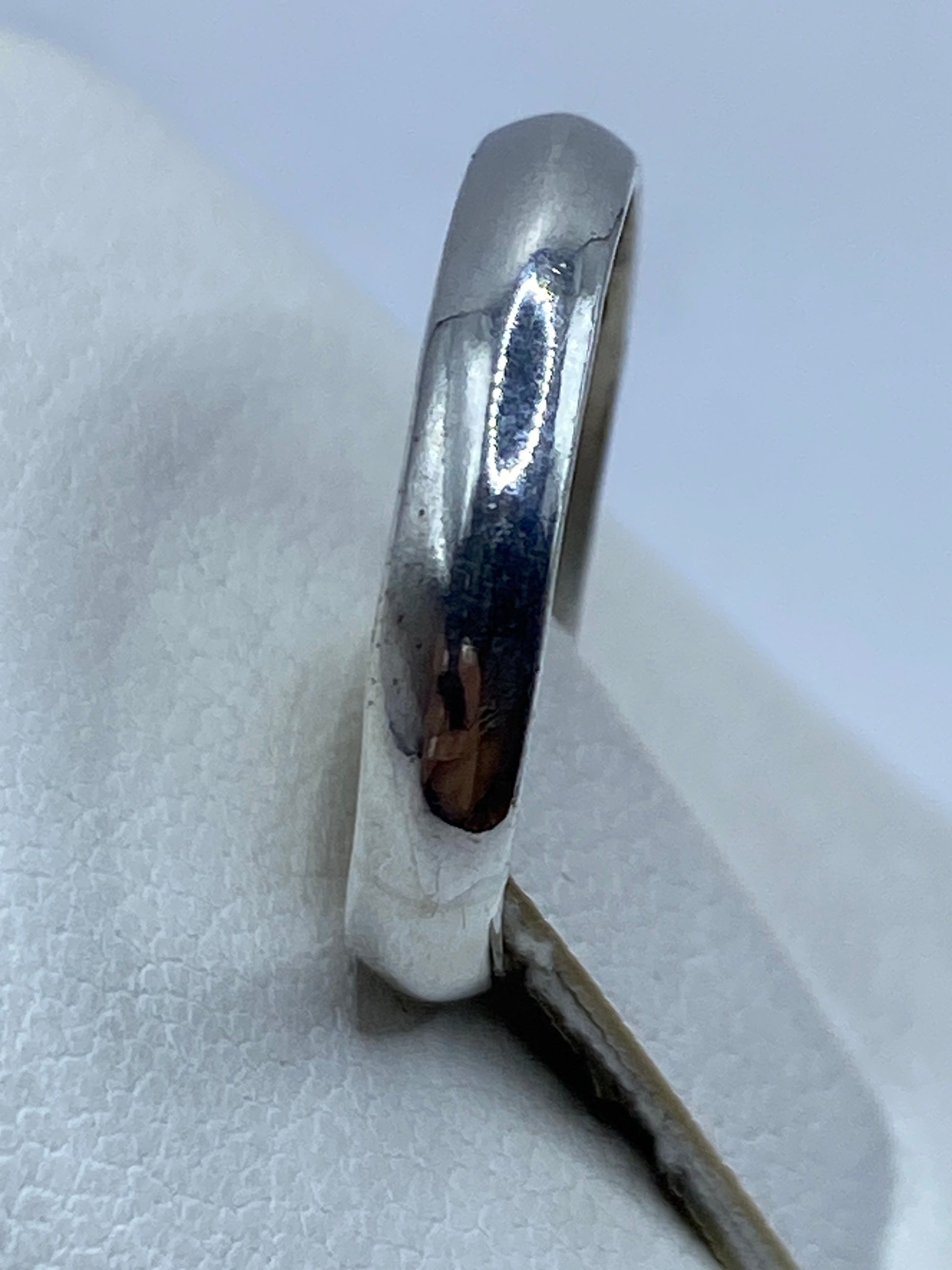 Anillo de plata puro en dedo de mujer mostrando el brillo espejo
