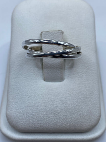 Anillo de plata eslabón entrelazado en forma de tres bandas cruzadas en el dedo