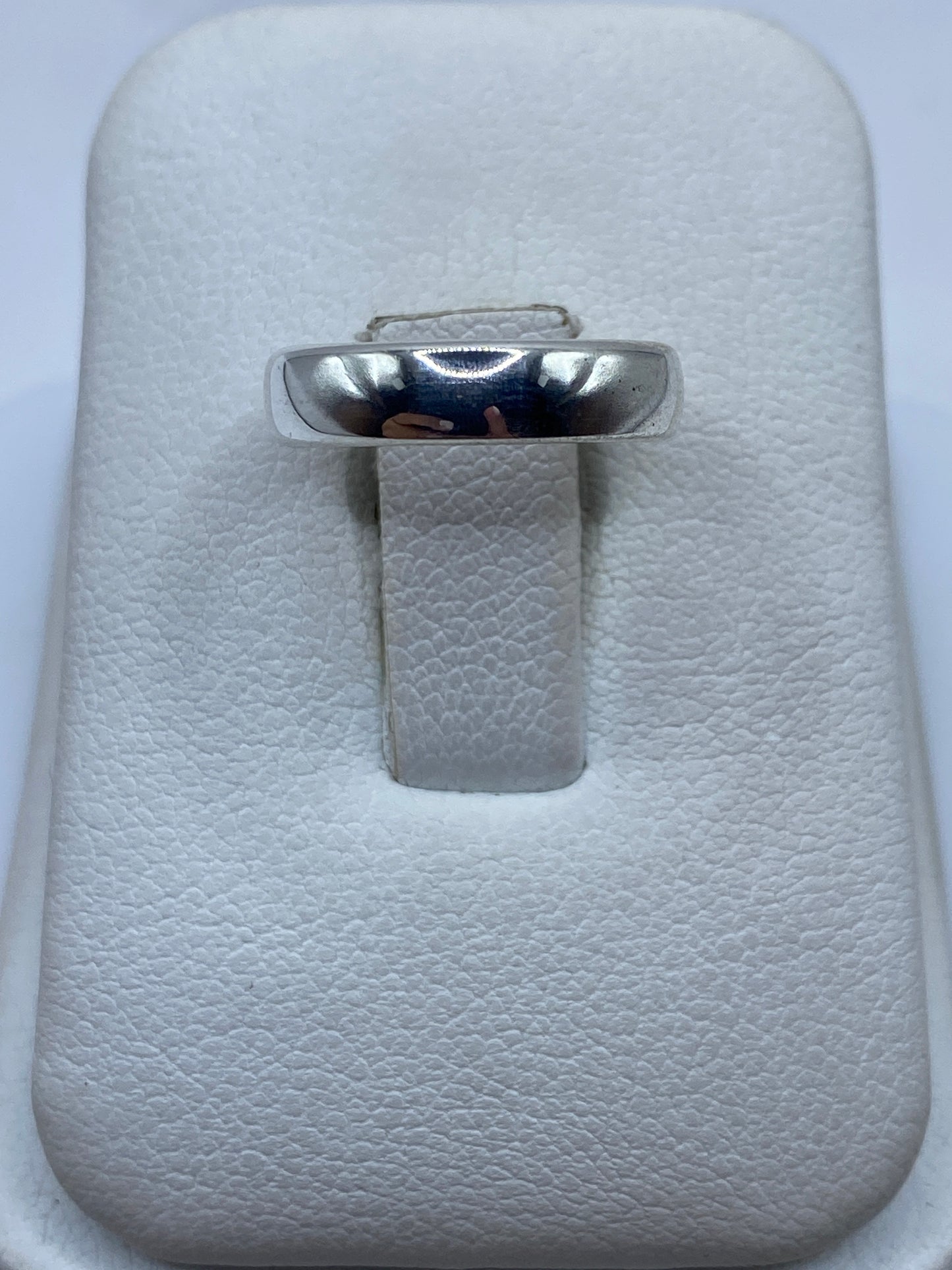 Anillo de plata pulida minimalista en estuche blanco, vista superior