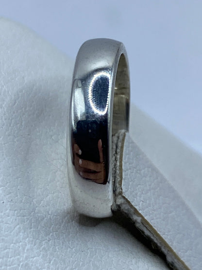 Anillo minimalista de plata en dedo de mujer con sello .925