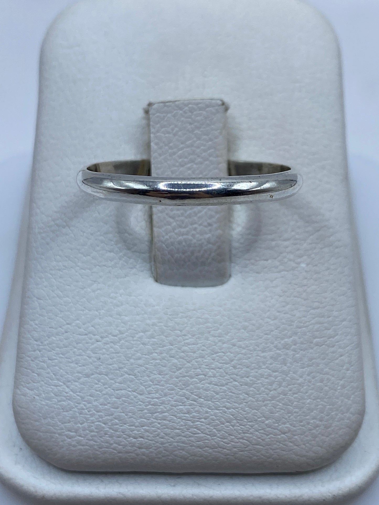 Anillo de plata banda pulida minimalista en dedo de mujer