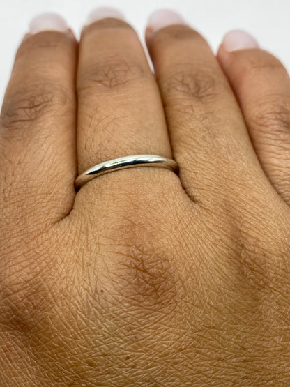Anillo de plata pulida sobre fondo blanco, diseño limpio y moderno